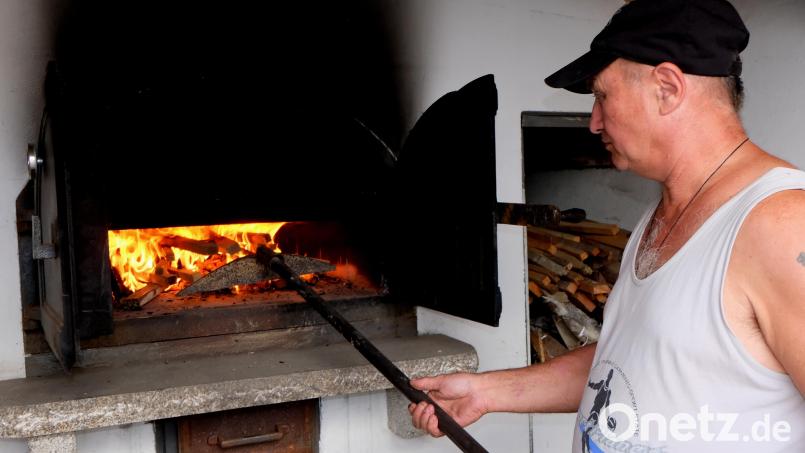 Backofenwart Sigi Schell heizt den Holzbackofen wieder an. Archivbild: le