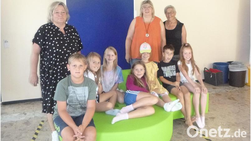 Die Vorsitzende des Fördervereins, Monika Ermer (rechts), übergab mit Monika Borowski das grüne Sofa an Rektorin Christine Schneider (links) und die Kinder. Bild: amö