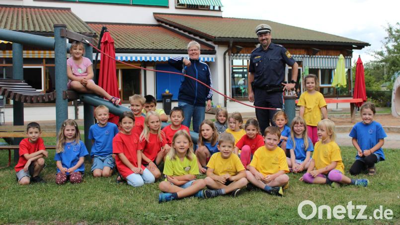 Nach einem kleinen Spaß mit Lisa (im Hintergrund, Mitte), brachte Polizist Carsten Landgraf (im Hintergrund, rechts) den Kindern spielerisch die wichtigsten Verhaltensregeln im Straßenverkehr bei. Bild: fks