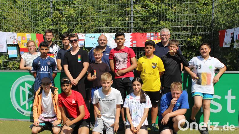 Sportliches Highlight an der Dreifaltigkeits-Mittelschule: die Fußball-Weltmeisterschaft in Katar: (hinten, von links) Konrektorin Stefanie Löffler, Stadionsprecher/Schiedsrichter Philipp Keilholz, Zeitnehmer Amjad Khalaf (9b), Organisator Thomas Gebele und BFV-Bezirksvorsitzenden Thomas Graml nahmen die Siegerehrung vor: (Von links) 1. Argentinien (D-5/6), 2. Deutschland (Lehrerteam), 3. Frankreich (5b), 4. Spanien (7a), 5. Kroatien (5c), 6. Niederlande (6a) sowie (kniend) 7. England (7b), 8. Katar (8c), 9. Schweiz (5a), 10. Portugal (8a), 11.Brasilien (8b), 12. Belgien (6b). Bild: gel