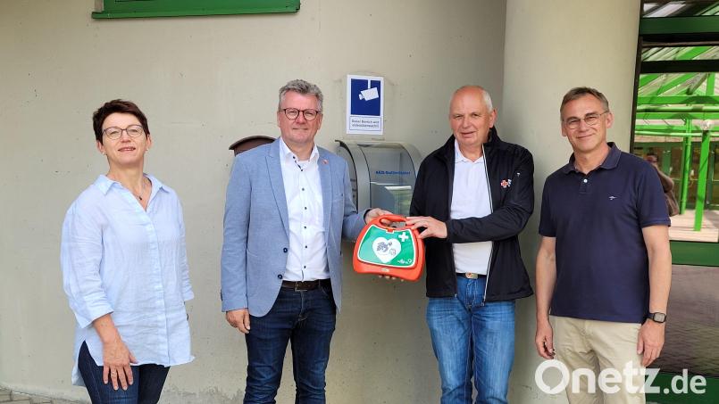 Er kommt hoffentlich nie zum Einsatz, aber im Notfall ist er da: (von links) Ordnungsamtsleiterin Rosalia Wendl, Bürgermeister Michael Göth, Erwin Gräml vom Roten Kreuz und Rektor Peter Danninger freuen sich über den neuen Defibrillator am Eingang der Krötensee-Mittelschule. Bild: Kerstin König/exb
