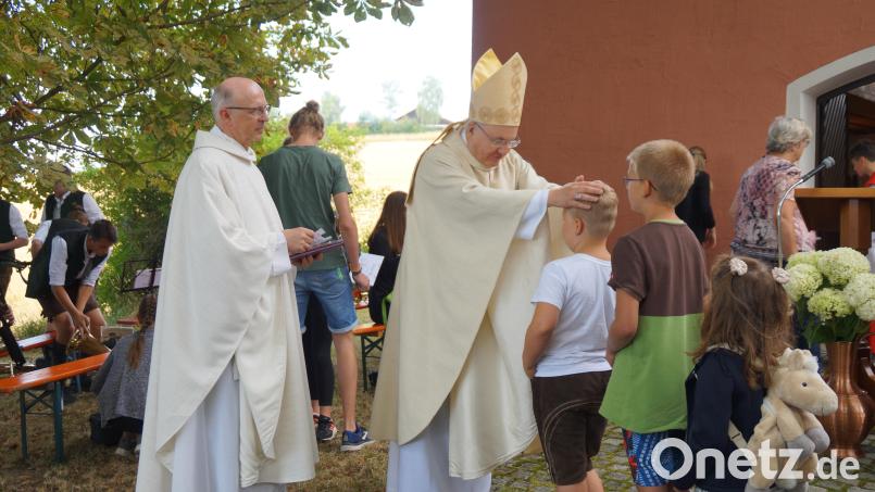 Bischof Dr. Rudolf Voderholzer segnete nach dem Pontifikalgottesdienst vor der Jakobikirche die Kinder. Pfarrer Herbert Rösl überreichte ein Bildchen des Bischofs. Bild: wel