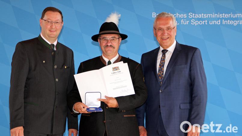 Anton Hirnet (Mitte) freut sich über die von Staatsminister Joachim Herrmann (rechts) und Christian Kühn verliehene Ehrenmedaille. Bild: Bayerisches Staatsminister des Inneren, für Sport und Integration