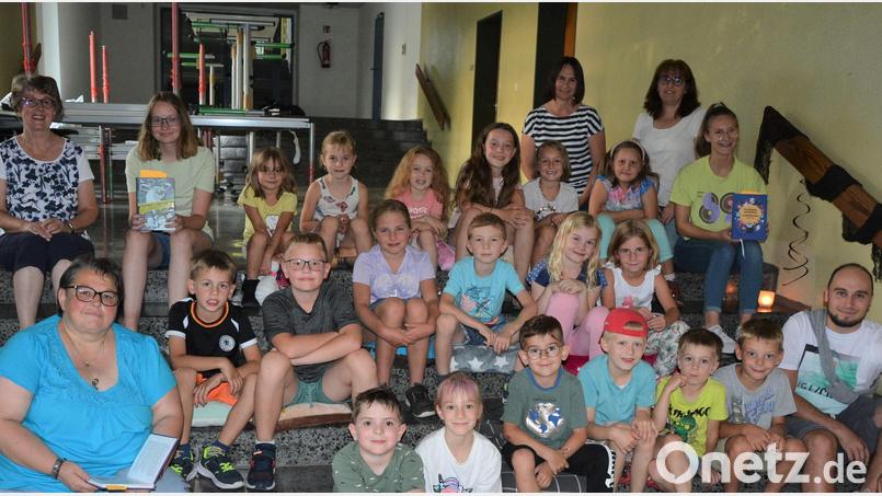 Mit einer schaurigen Lesenacht in der Pfarrbücherei wurde in Konnersreuth das diesjährige Ferienprogramm eröffnet. Die Kinder waren in zwei Gruppen, hier die kleineren Sprösslinge, in die Pfarrbücherei gekommen, wo sie auf den Treppen zur Grundschule den schaurigen Geschichten lauschten. Mit dabei Büchereileiterin Petra Günthner (links) und ihr Büchereiteam, sowie Jugendbeauftragter Manuel Ernst (rechts). Bild: jr