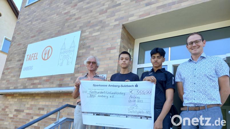Tafel-Chef Bernhard Saurenbach (links) freut sich über die Spende der Dreifaltigkeitsmittelschule Amberg. Den Scheck übergaben (weiter von links) Brian Schaffner, Ali Resa Haidari und Lehrer Christoph Hollweck. Bild: Dreifaltigkeits-Mittelschule/exb