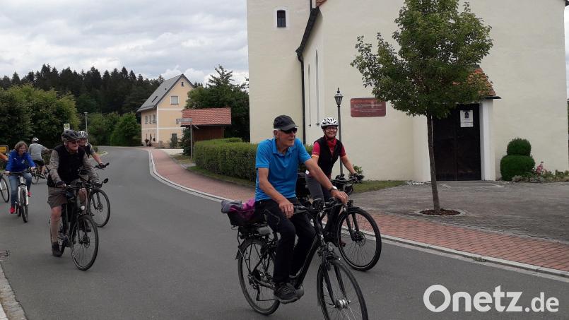 Sport und Glaube verband die Radtour auf dem Simultankirchenradweg. Kräftig in die Pedale traten auch Walter Schraml (vorne), zuständig für Route 2 des Simultankirchenradwegs, und Gerda Stollner (dahinter), Organisatorin der Radtour und zuständig für die Route 1. Im Hintergrund ist die Martin-Luther-Kirche in Poppberg zu sehen. Bild: Roland Klein/exb