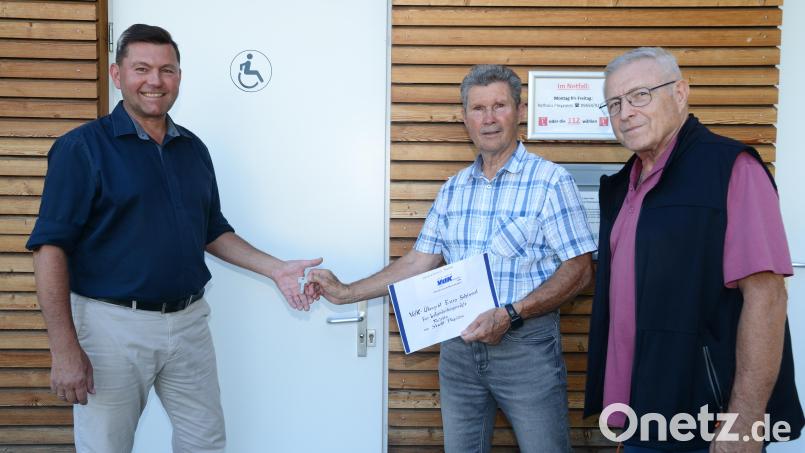 Bürgermeister Rainer Rewitzer (links) erhält von VdK-Ortsvorsitzendem Josef Rewitzer (Zweiter von links) symbolisch den "Euro-WC-Schlüssel" für die Toilettenanlage am Zimmerplatz. VdK-Schriftführer Peter Trstan freut sich über diese neue Errungenschaft als Teil der Barrierefreiheit. Bild: bey