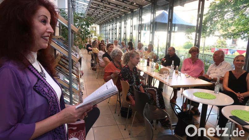 Dalal Makari-Pausch erläutert an der Seite von Wolfgang Schmid den Gästen der Vernissage in arabischer Gedichtsform die Hintergründe ihrer Arbeit. Bild: Kunz