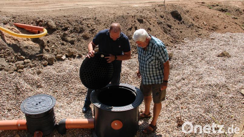Eine 25.000 Liter Regenwasser fassende Zisterne ist das Herzstück der neuen Beregnungsanlage auf dem DJK-Sportgelände. DJK-Vorsitzender Rupert Troppmann und Platzwart Jürgen Greiner werfen einen Blick hinein. Bild: prh