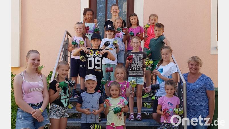 Stolz präsentieren die Kinder ihre selbstgebastelten Windspiele, die zugleich als Insektenhotel dienen. Melanie Schultes (hinten, Zweite von links) und Monika Schultes (vorne rechts) leiteten den Bastelnachmittag. Bild: ban