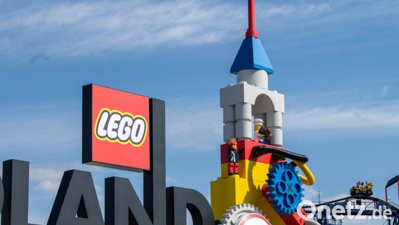 Neben dem Logo am Eingang zum Legoland ist eine Achterbahn zu sehen. Bild: Stefan Puchner/dpa/Archivbild