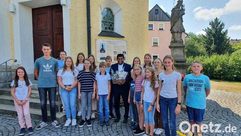 In seiner zweijährigen Wirkungszeit in der Pfarreiengemeinschaft Plößberg kümmerte sich Pfarrvikar Pater John (Mitte) insbesondere um die Ministrantenarbeit. Diese überreichten ihm zum Abschied Geschenke als Dankeschön. Bild: flt