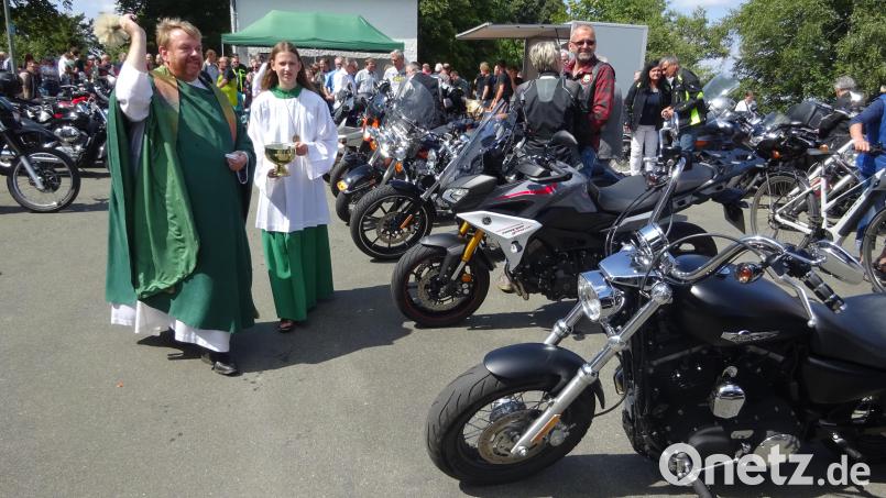 Pfarrer Albert Hölzl segnet nach dem Gottesdienst die vielen Bikes. Bild: fvo