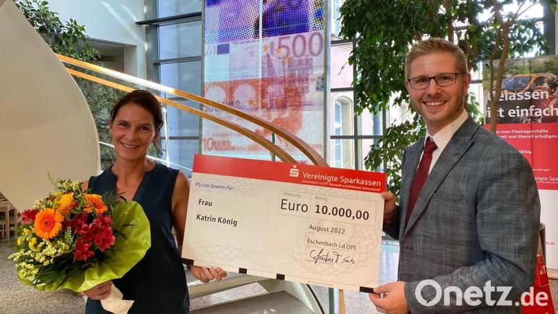 Katrin König aus Eschenbach (links) freut sich über 10.000 Euro aus dem &quot;PS Sparen &amp; Gewinnen&quot;. Kundenberater Tobias Lautner (rechts) überreicht Blumen und einen symbolischen Scheck. Bild: Vereinigte Sparkassen/exb