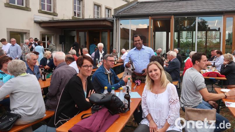 Stadtpfarrer Pater Robin Xavier (Mitte) freut sich beim Pfarrfest über nette Begegnungen auch außerhalb des Gotteshauses. Bild: rha