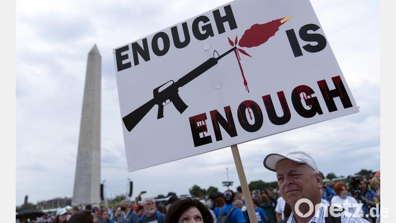 Anti-Waffen-Protest in den USA: Ein Demonstrant trägt ein Plakat mit der Aufschrift „Enough is Enough“ (genug ist genug). Symbolbild: Jose Luis Magana, dpa