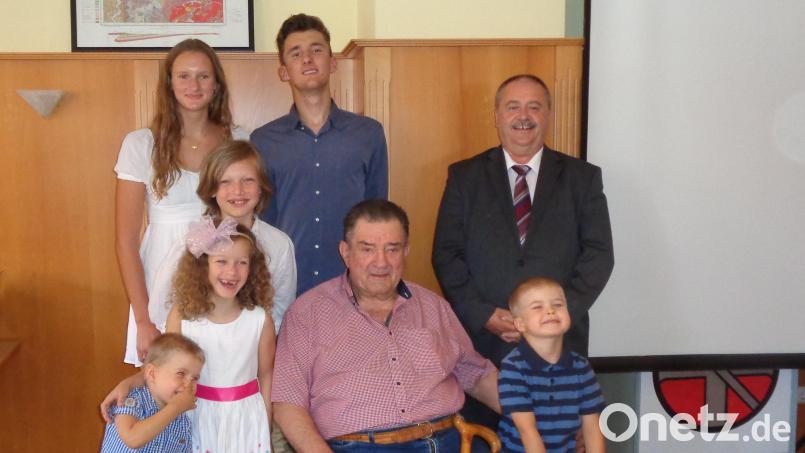 Der Jubilar Andreas Flierl (sitzend) zusammen mit seinen Enkeln Johannes, Sofia, Marlene, Lukas, Andreas, Sebastian und Bürgermeister Peter Dotzler (von links). Bild: dpe