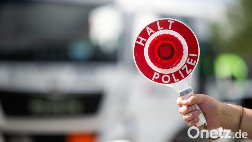 Ein Polizist hält bei einer Verkehrskontrolle eine Polizeikelle in der Hand. Bild: Jonas Güttler/dpa/Symbolbild