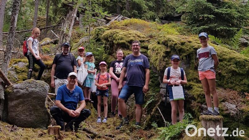 Kinder und Jugendliche hatten mit dem Kolpingteam viel Spaß im Wald. Interessiert lauschten sie dem, was Landschaftsgärtner Hubert Schinner (vorne, sitzend) über Flora und Fauna erzählte. Bild: ban