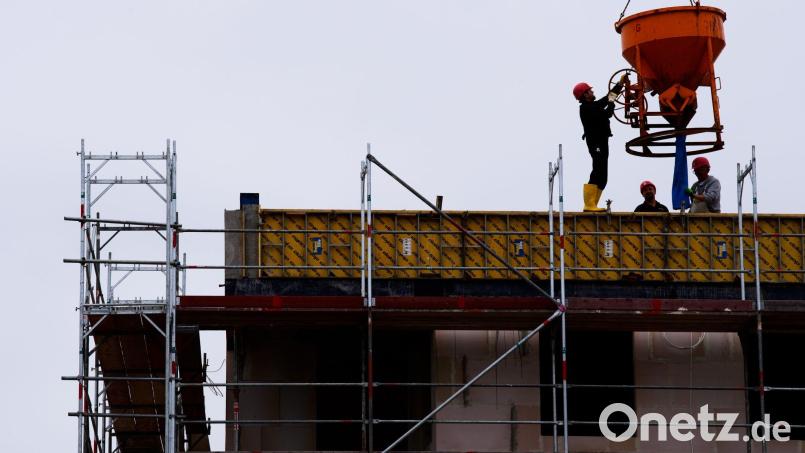 Arbeiter stehen auf einer Baustelle eines Wohngebäudes. Symbolbild: Soeren Stache/dpa-zentralbild/dpa