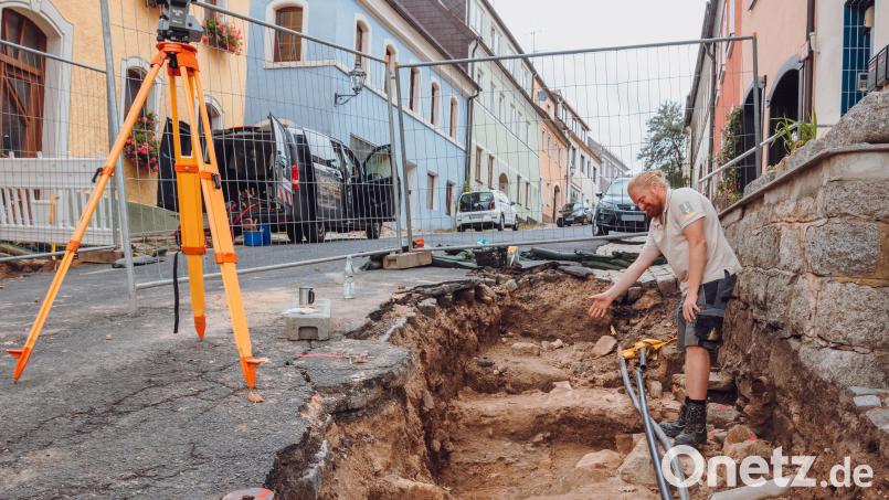 Archäologe Matthias Hoffmann von der Firma In Terra Veritas aus Weiden deutet auf einen Bereich in der Bärnauer Silberstraße. An dieser Stelle sind Steinblöcke der früheren Stadtmauer entnommen worden. Vor der Sanierung des Silberbergs wurden in zwei Abschnitten der Straßen archäologische Untersuchungen durchgeführt. Bild: sfo