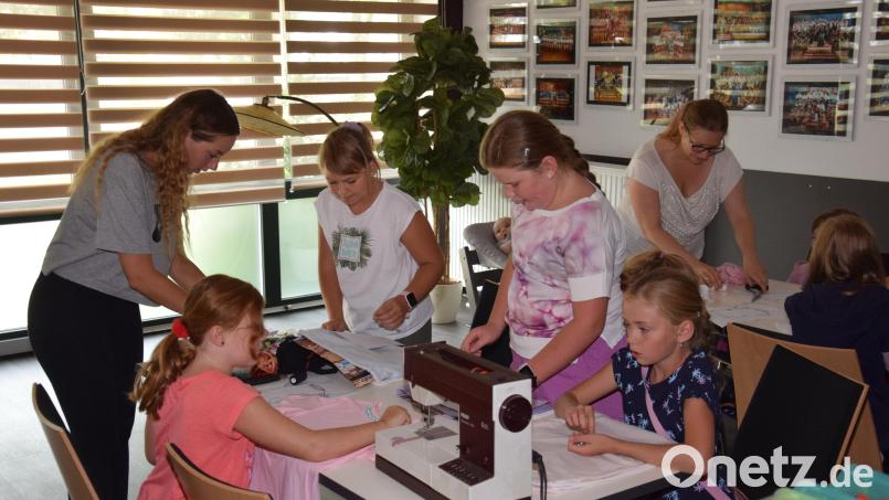 Mit ein bisschen Unterstützung gelingt es den Kindern, auf ihre T-Shirts und Stoffbeutel Perlen zu nähen. Bild: fla