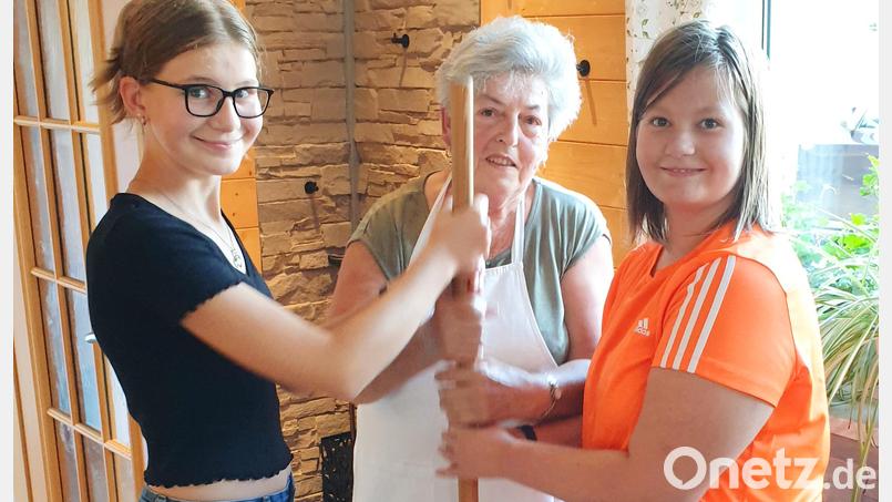 Jung und Alt butterten aus. Wie es geht, zeigte Irmgard Deglmann (Mitte). Bild: njn