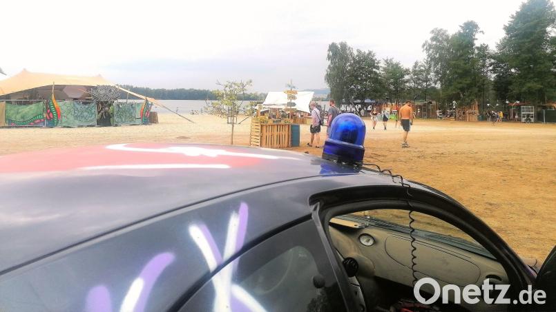 Das Mahagoni-Festival am vergangenen Wochenende in Schwandorf schlägt mehr Wellen als der Klausensee (im Hintergrund), an dessen Ufer es stattfand. Immer wieder musste die Polizei anrücken, weil sich Anwohner über zu laute Musik beschwert hatten. Das Auto samt Blaulicht auf dem Bild diente bei der Veranstaltung als Dekoration. Bild: Keller