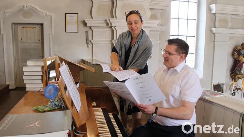 Chorleiterin Stefanie Rüger und Organist Holger Popp sehen sich die geplante Messe für die Orgelweihe an. Bild: Popp, Holger