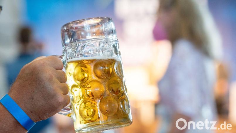 Eine Maß mit Bier wird beim Politischen Frühschoppen Gillamoos hochgehalten. Bild: Armin Weigel/dpa