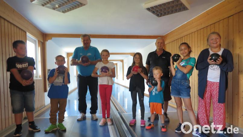 Geduldig gaben die beiden SKC-Vorsitzenden Johann Sertl und Erhard Binner (hinten von links) den Mädchen und Buben praktische Tipps zum Kegelsport. Bild: jzk