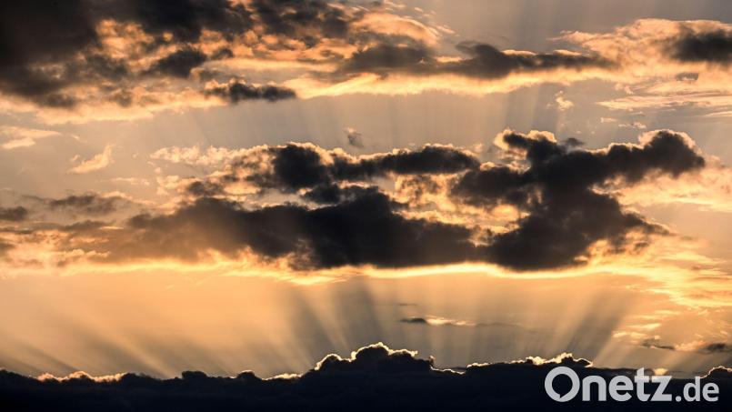 Während das Wochenende noch eher windig, wolkig und regnerisch wird, kann man am Horizont schon wieder die Sonne sehen: Die neue Woche soll wieder angenehm warm werden. Symbolbild: Federico Gambarini/dpa