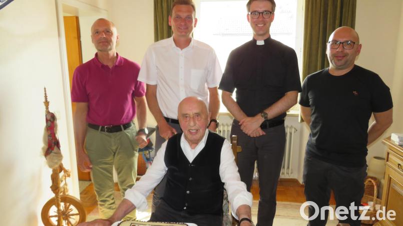 Bürgermeister Ernst Schicketanz und Pfarrer Thomas Kopp (stehend, Zweiter und Dritter von links) gratulieren Josef Greiner (sitzend) im Beisein seiner Söhne Josef (links) und Peter (rechts) zum 90. Geburtstag.. Bild: adj