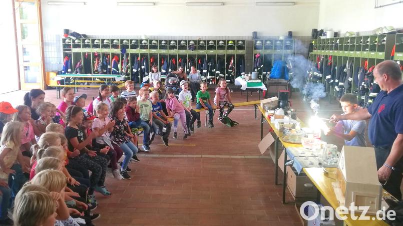 Der Fachbereichsleiter für Brandschutzerziehung beim Kreisfeuerwehrverband Neustadt, Thomas Mathes (rechts), zeigt den Kindern, was passiert, wenn eine Dose brennt. Bild: fjo