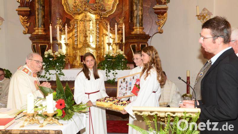 Oberministrant Michael Zehent (rechts) gratuliert Pater Reinhold Schmitt namens aller Ministranten zum 90. Geburtstag. Dafür gab von den Ministranten einen großen Kuchen mit der Zahl &quot;90&quot;. Bild: bey