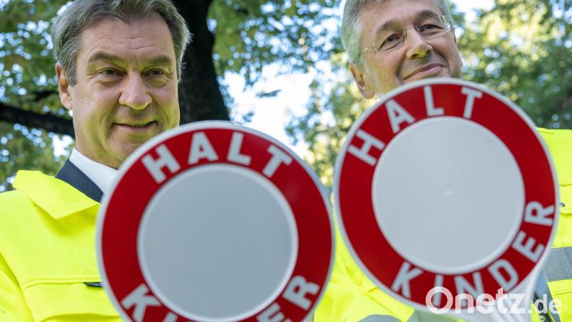 Ministerpräsident Markus Söder (links) und Kultusminister Michael Piazolo mit Warnwesten und Haltekelle der Schulweghelfer an einem Strassenübergang. in München, Bild: Peter Kneffel/dpa