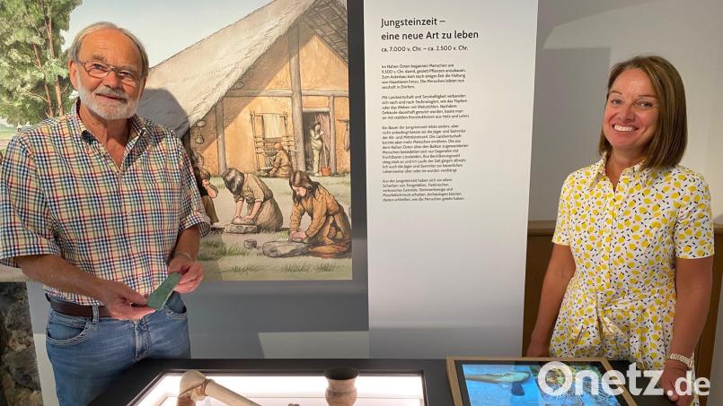 Das Kupferbeil, das Kurt Engelhardt in Händen hält, hat seinen Platz neben der Replik in einer Ausstellungsvitrine des Pfreimder Stadtmuseums gefunden. Rechts im Bild Museumsleiterin Carola Reul. Bild: Völkl