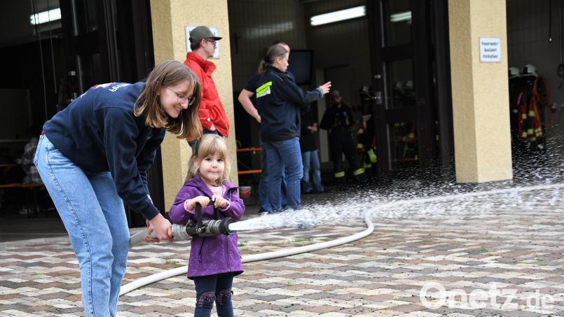 Die dreijährige Lena, eine der Teilnehmerinnen an der Ferienprogramm-Veranstaltung der Feuerwehr, übt mit stellvertretender Jugendwartin Hannah Hochwart schon das Löschen. Bild: hcz