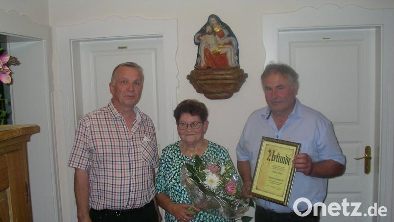 Maria Zölch (Mitte) wurde nach über 35 Jahren Chorleiterin-Tätigkeit verabschiedet. Sie wurde zur Ehrenchorleiterin ernannt. Karl Haubner von der Kirchenverwaltung (links) und Chorvorstand Gregor Mark (rechts) gratulierten. Bild: Wilhelm Trisl/exb