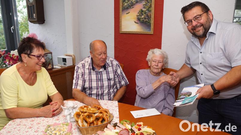 Bürgermeister Thomas Kaufmann hatte für Hildegard Hösl das Landkreisbuch als Geschenk mitgebracht. Der Jubilarin gratulierten auch Sohn Karl und dessen Frau Roswitha (von rechts). Bild: bkr