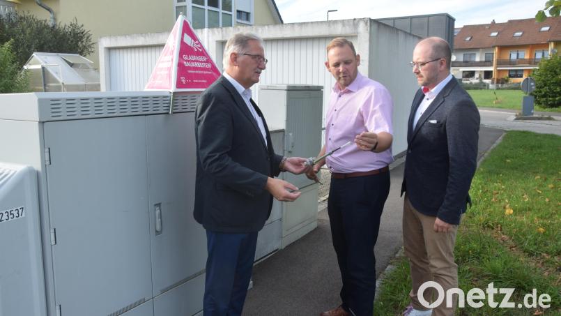 Glasfaser nicht etwa nur bis zu den Verteilerkästen und ab da Kupfer. Glasfaser direkt ab hier ins Haus, kostenneutral für Gemeinde und Hauseigner. Rainer Spiegel und Enrico Delfino von der Telekom zeigen Bürgermeister Josef Hammer (von rechts) ein Glasfaserkabel, das ab hier in die Häuser läuft. Danach erfolgt Vertragsunterzeichnung im Gemeinderat. Bild: fz