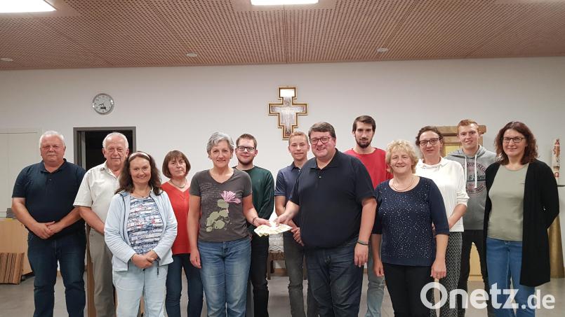 Die Pfarrgemeinderats-Sprecherinnen Christine Ring (Fünfte von links) und Elisabeth Völkl (Vierte von rechts) überreichen zusammen mit dem Gremium eine Spende von 1600 Euro aus dem Erlös des Pfarrfestes an Pfarrer Udo Klösel für die Restaurierung des Heiligen Aurelius. Bild: gi