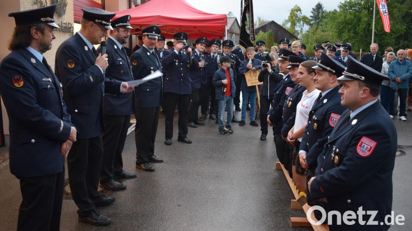 Auf Holzscheiten kniend baten die Feuerwehrleute aus Glaubendorf die Oberköblitzer Feuerwehr um die Übernahme der Patenschaft. Bild: bnr