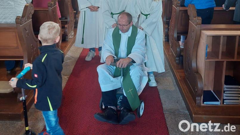Selbst Pfarrer Thiermann brachte ein kleines Gefährt zum Familiengottesdienst mit Kinderfahrzeugsegnung mit. Bild: Pfarramt Plößberg/exb