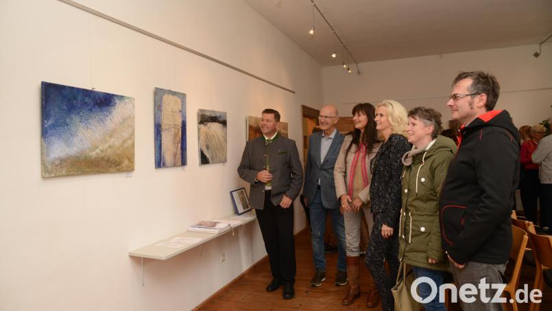 Bürgermeister Rainer Rewitzer (links), Zweite Bürgermeisterin Andrea Lang (Vierte von links) und Besucher der Vernissage (rechts) bestaunen die Werke von Claudia Biller-Fütterer (Dritte von links). Clemens Fütterer (Zweiter von links) beschreibt die Werke seiner Ehefrau, die verwendeten Materialien und Ideen. Bild: bey
