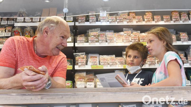 Lukas (11) und Xenia (11) dürfen beim Jungreportertag des Ferienprogramms von Oberpfalz-Medien und dem Stadtjugendring Weiden einen Blick in Dieter Liebes Gewürzstand auf dem Wochenmarkt werfen. Bild: Gabi Schönberger