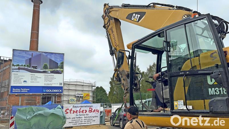 Oberbürgermeister Oliver Weigel enthüllte mit einem Bagger die Bautafel des neuen Parkhauses. Bild: Sophia Goldner/fph
