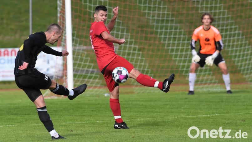 Johannes Renner (Grafenwöhr) zieht ab, der Vohenstraußer Michael Gotfryd stellt sich dem Schuss in den Weg. Die Bezirksligapartie zwischen der SpVgg Vohenstrauß und der SV Grafenwöhr endete 2:2. Bild: Büttner, Gerhard