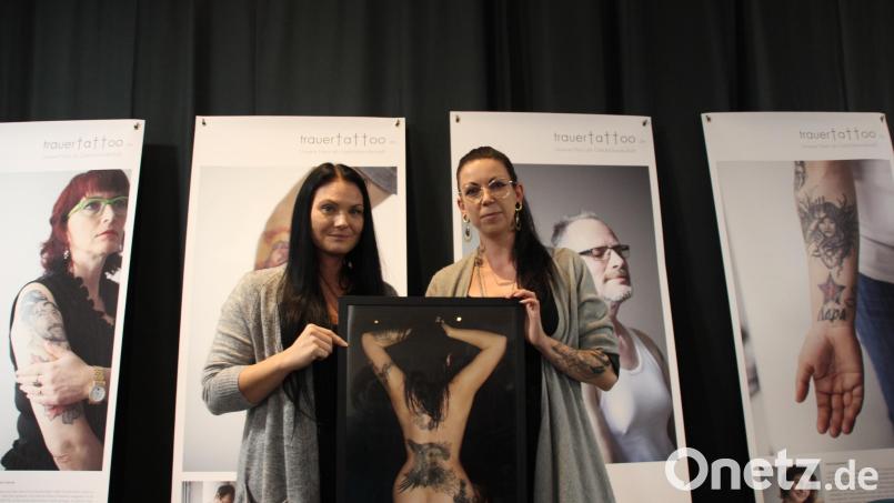 Jenny Greathous als eine der Protagonistinnen der Ausstellung „Trauertattoo – Unsere Haut als Gefühlslandschaft“ und die Tätowiererin Daniela Hautmann zeigen eines der Bilder der Ausstellung. Bild: ads
