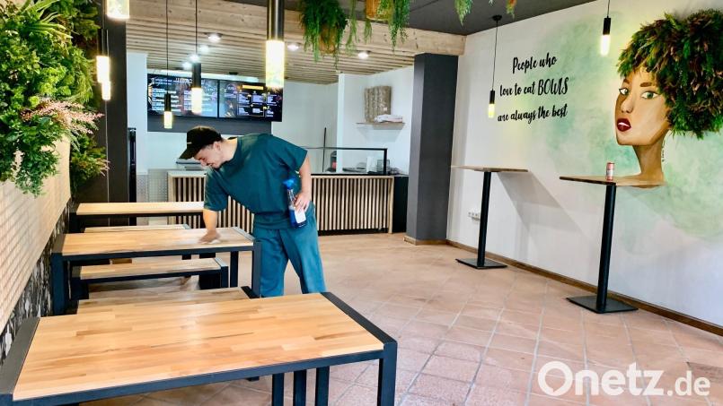 Mitarbeiter Blendi Gashi wischt noch einmal die Tische ab, bevor der neue Bowls-Laden am Mittwoch am Unteren Markt in Weiden eröffnet. Bild: Gabi Schönberger